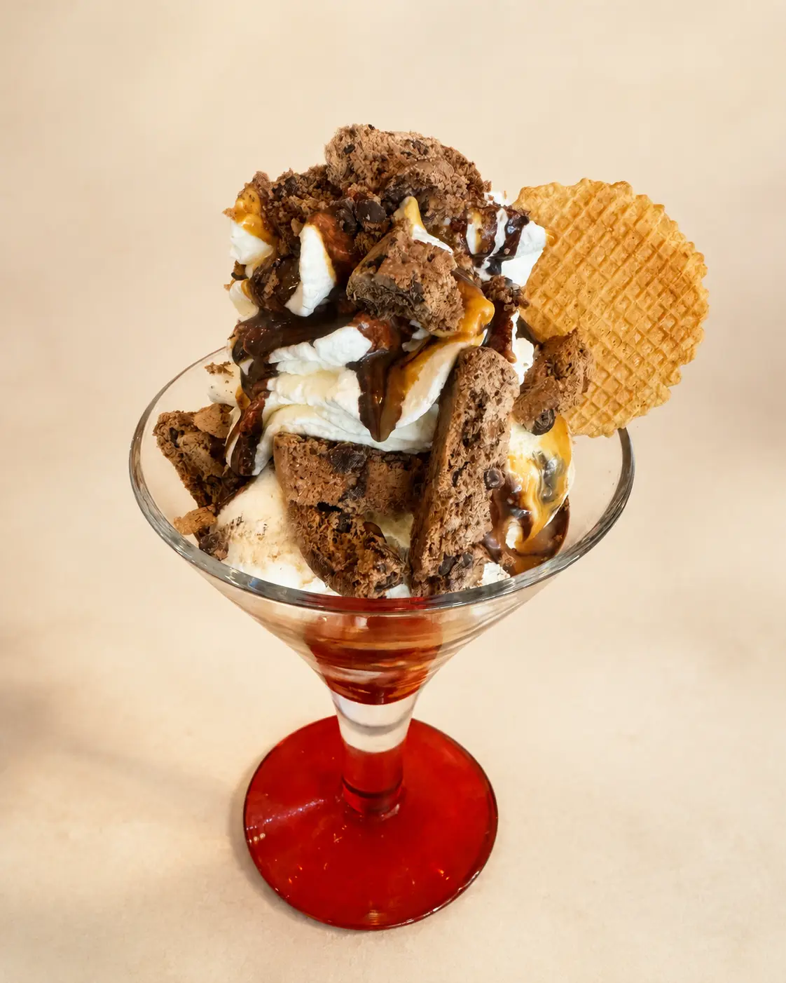 Cookies-Eisbecher mit Schokolade und Karamell auf neutralem Hintergrund