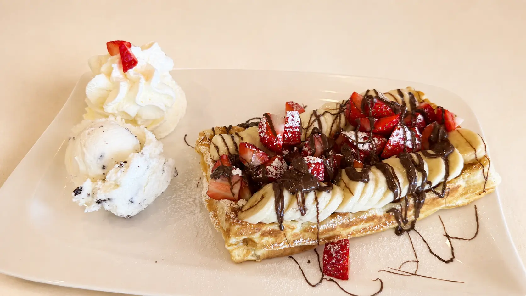 Nutella-Waffel mit Eis, Sahne, Banane und Erdbeeren